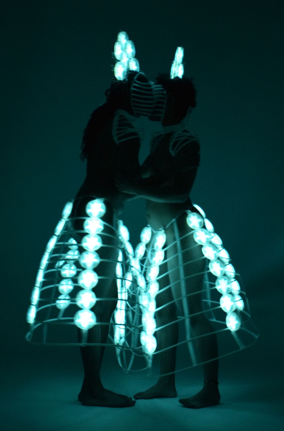 Embrace, two figures in a glowing bioluminescent costume