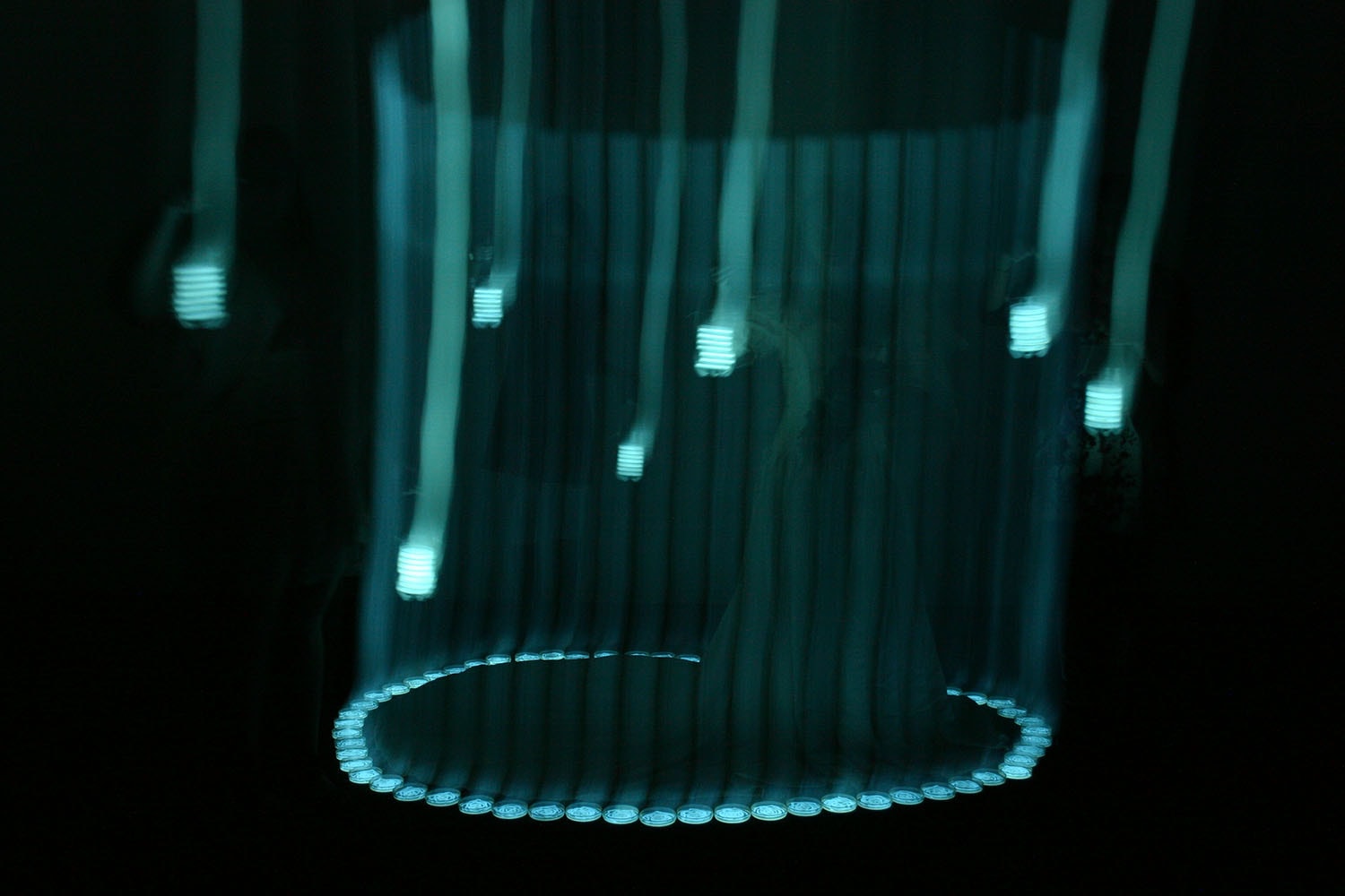 Bride Caged in Light, figures and cyan lights with a circular installation